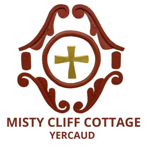 Misty Cliff Cottage Yercaud logo featuring ornamental design and golden cross